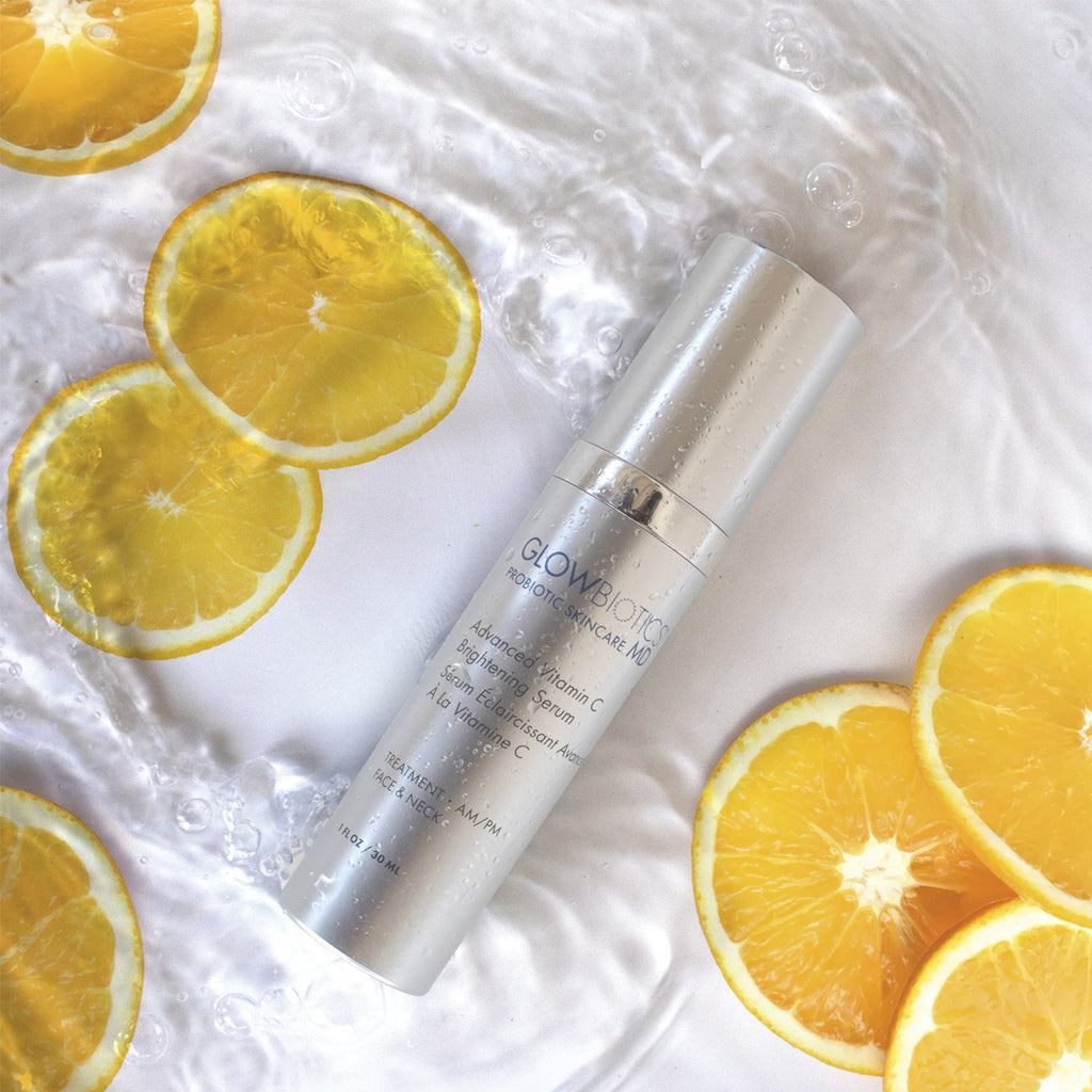Advanced Vitamin-C Brightening Serum with fresh orange slices on a sunny background