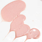 Close-up of shimmering pink serum texture on a white background