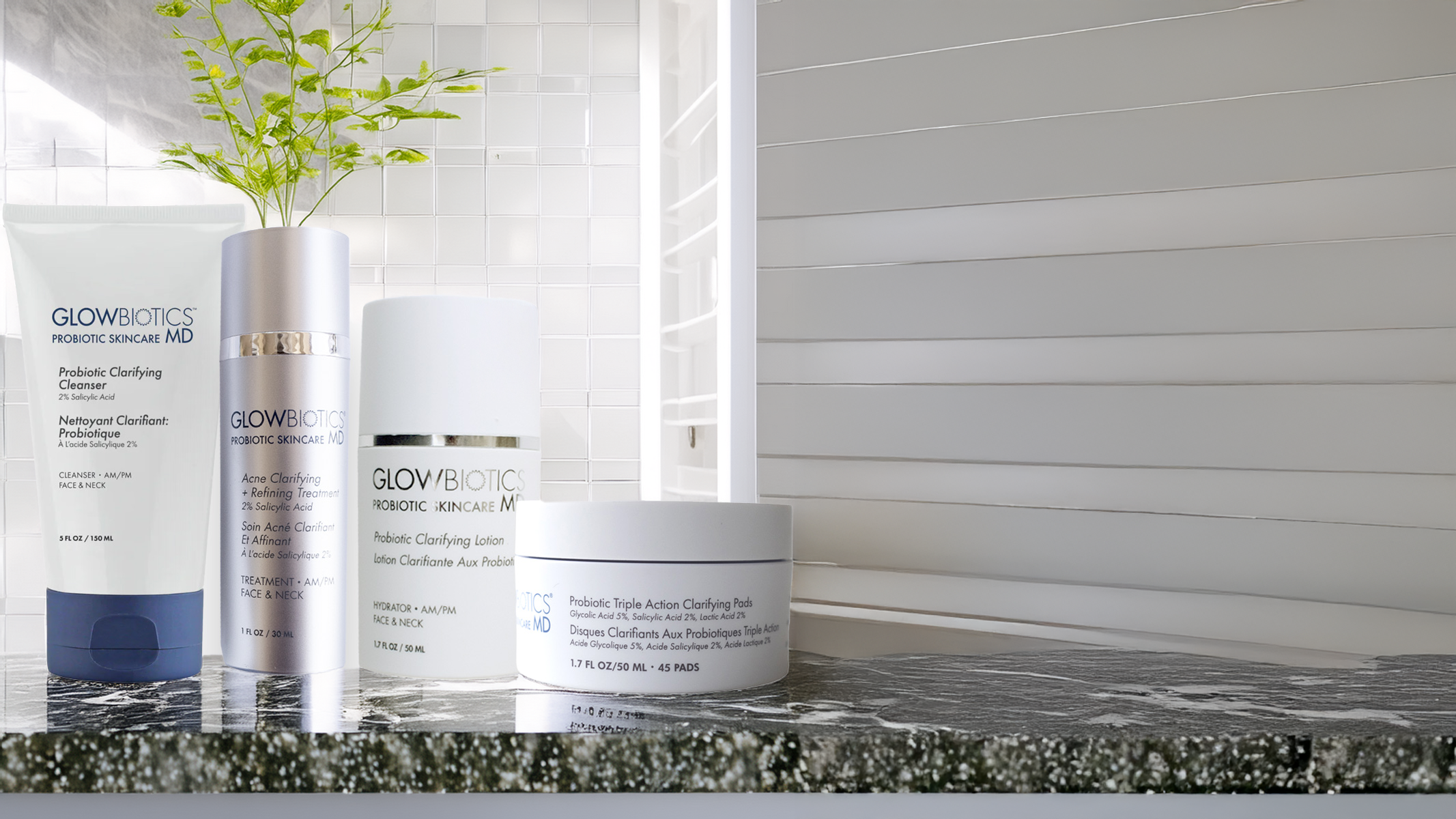 Glowbiotics Probiotic Acne Starter Kit—clarifying cleanser, lotion and treatment pads arranged on a bathroom counter.