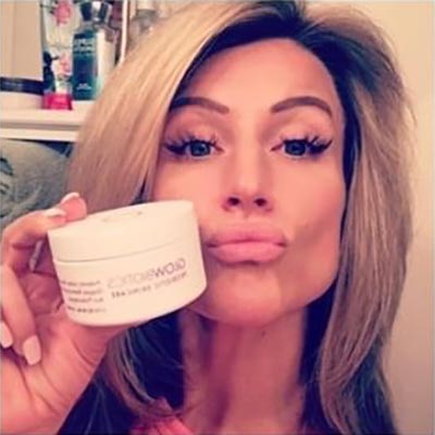 Woman presenting Glowbiotics probiotic clarifying pads jar