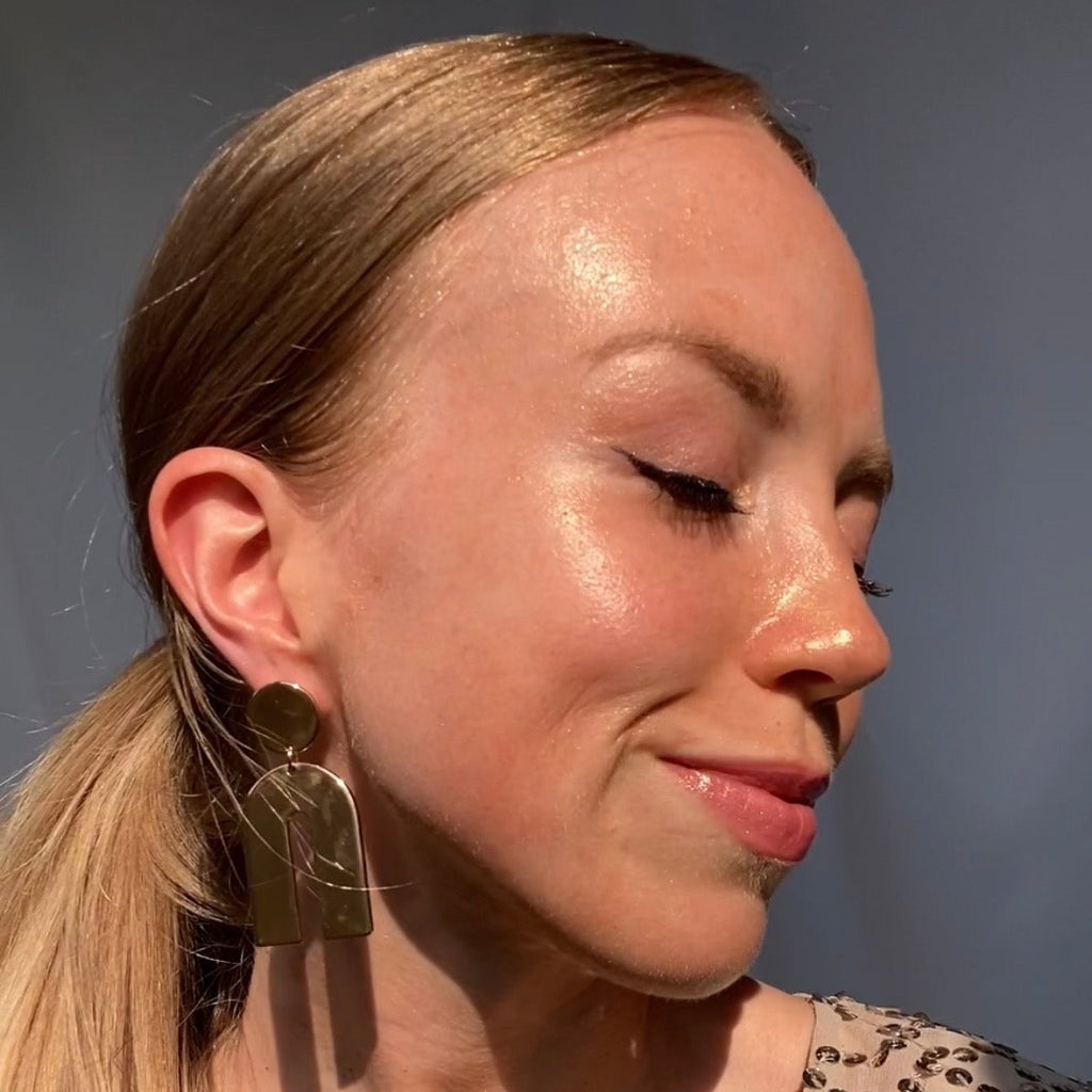 Woman with sun-lit, radiant skin showcasing the glow from Glowbiotics Bronze HydraGlow Illuminating Serum.