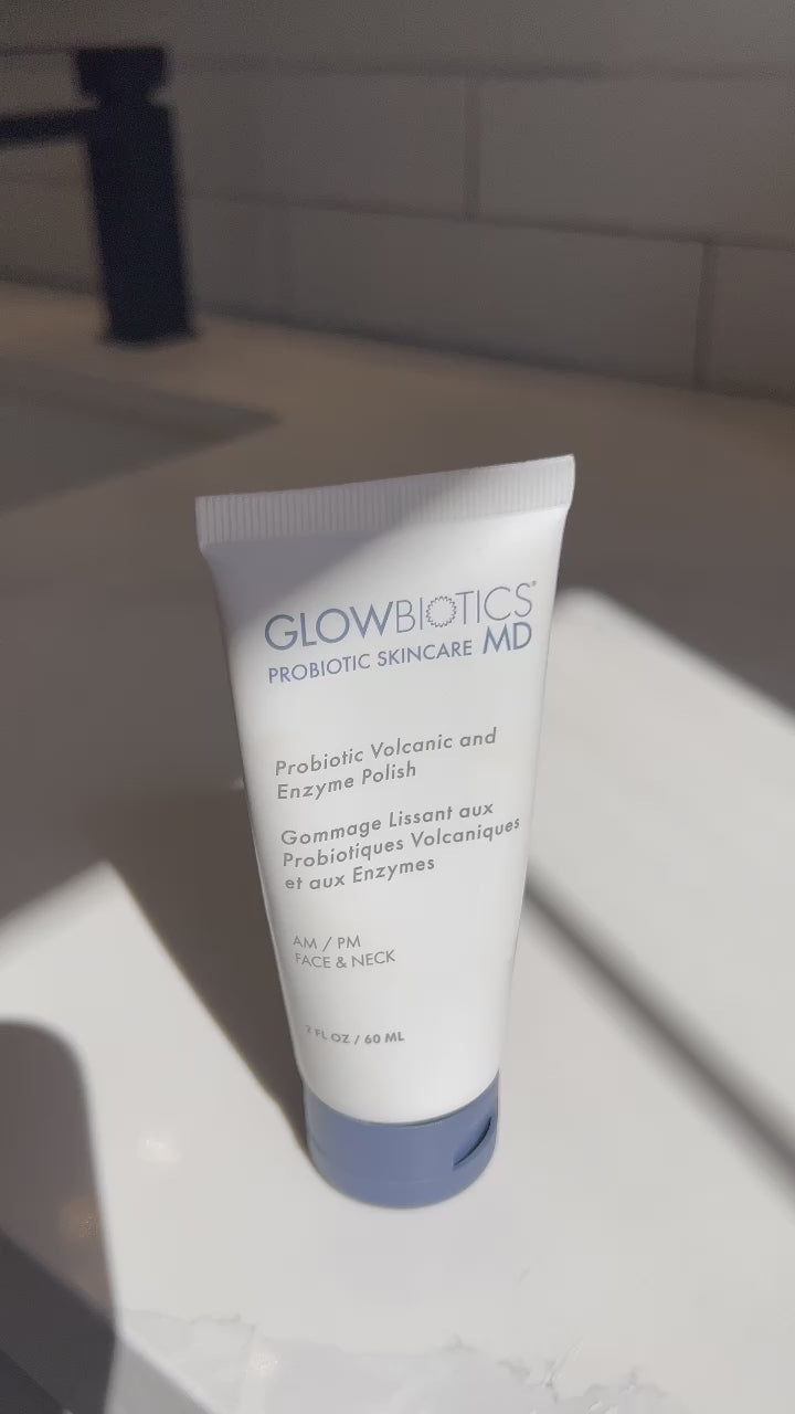 Tube of Glowbiotics Probiotic Volcanic and Enzyme Polish standing on a white surface with water running in the background