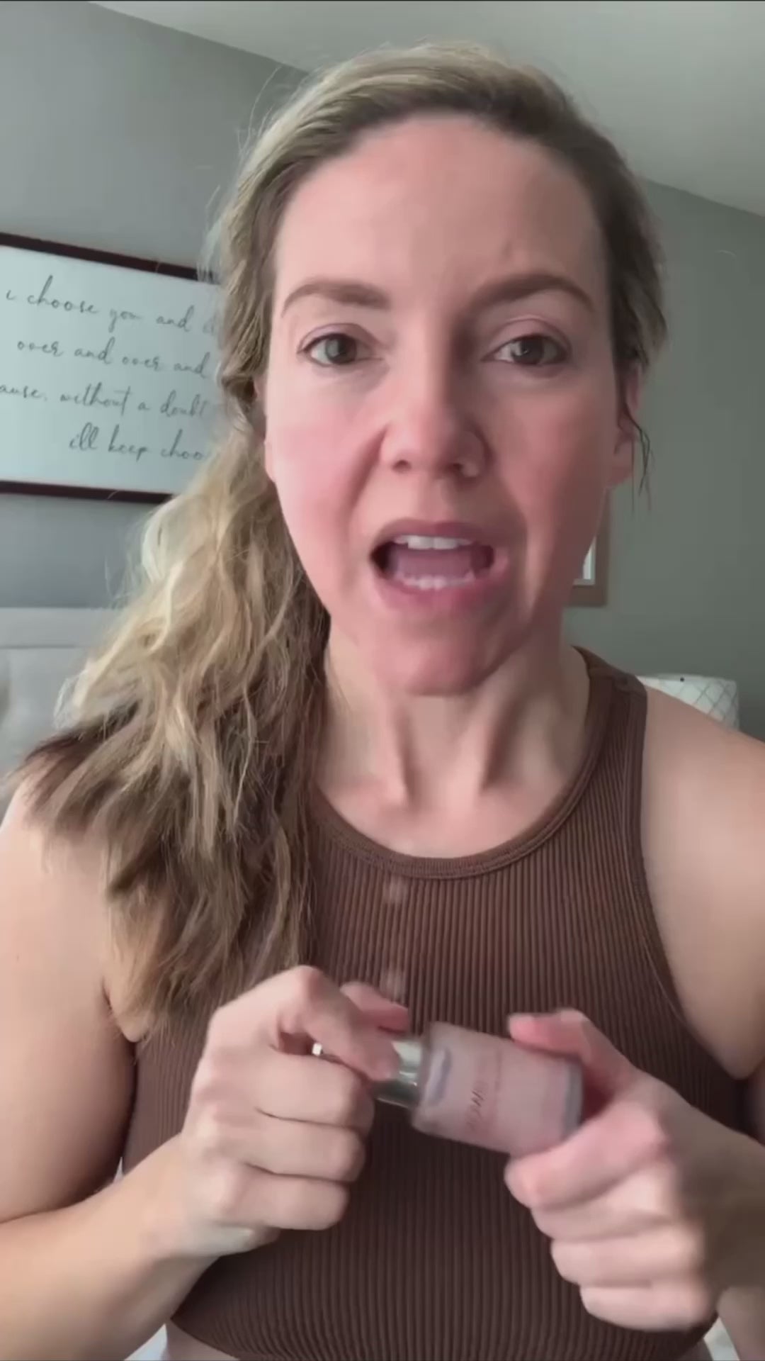 Video testimonial of a woman holding Glowbiotics Pink HydraGlow Illuminating Serum bottle.
