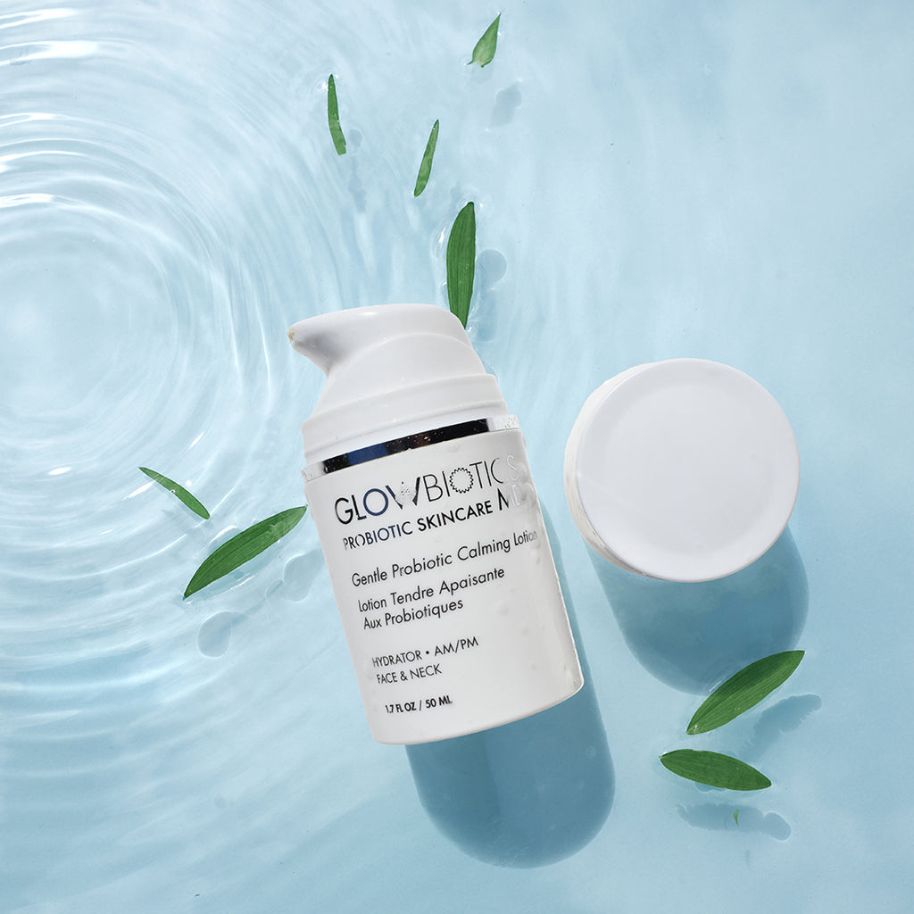 Glowbiotics Gentle Probiotic Calming Lotion jar and open lid floating on rippling water with green leaves