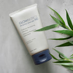 Glowbiotics Probiotic Revitalizing Cleanser tube on beige surface with green plant